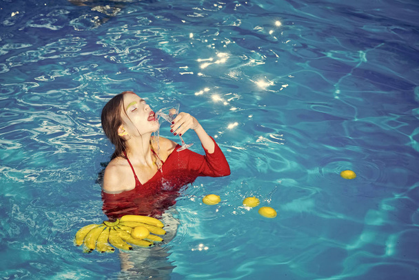 Woman relax in spa pool. woman with tropical fruit in pool. Vitamin in banana at girl sitting near water. Dieting and healthy organic food, vegetarian. Summer vacation and travel to ocean - Foto, Imagem