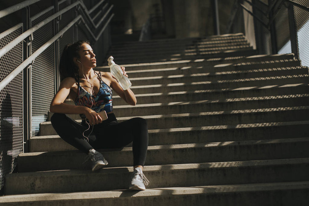 Merdivenlerde istirahat oldukça genç kadın atlet portresi - Fotoğraf, Görsel