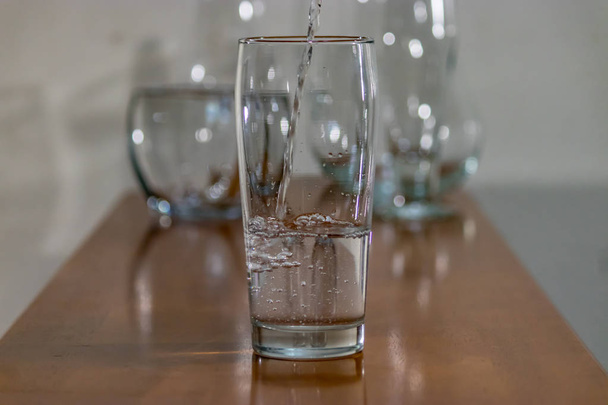 group of glasses on wood one with water - Photo, Image