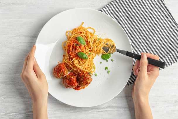Woman having pasta with meatballs and tomato sauce at table, closeup - Foto, imagen
