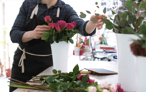 Male florist creating beautiful bouquet in flower shop - Foto, imagen