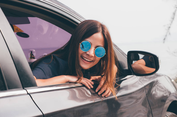 Азіатський жінка smilng з дзеркалом в машині. - Фото, зображення