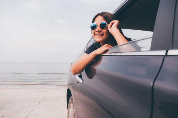 車のミラーを持つアジアの女性 smilng. - 写真・画像