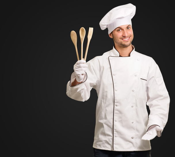 tahta kaşıklar işaret tutan erkek aşçı - Fotoğraf, Görsel