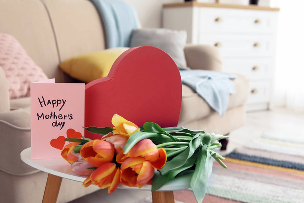 Gift box, tulips and greeting card for Mother's Day on table indoors - Foto, imagen