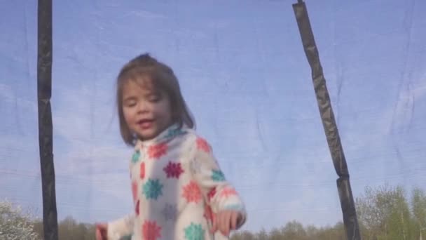 felice ragazza di tre anni che salta su un trampolino. Ritratto emotivo gioioso. Rallentatore
 - Filmati, video