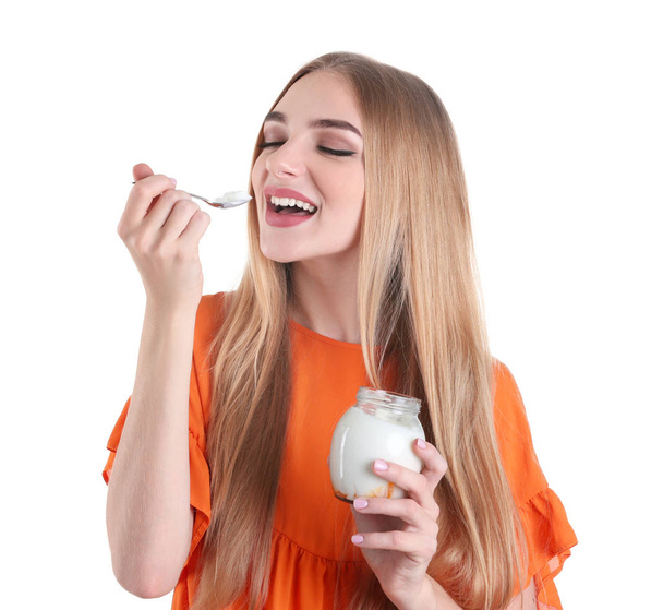 Young woman with yogurt on white background - Valokuva, kuva
