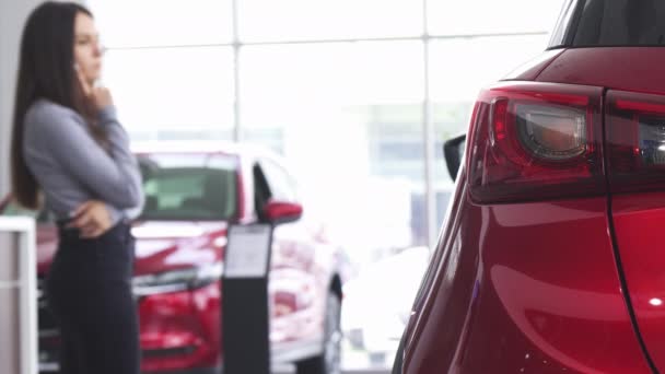 Θηλυκό πελάτη επιλέγοντας ένα νέο αυτοκίνητο στο σαλόνι αντιπροσωπεία - Πλάνα, βίντεο
