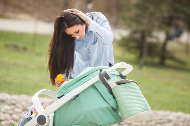 Young mother trying to calm down her little baby outdoors - Photo, Image