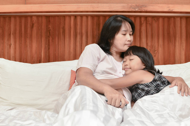 madre y su hija abrazándose mientras duerme
  - Foto, Imagen
