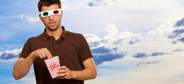 Людина їсть попкорн і дивитися 3d фільм
 - Фото, зображення