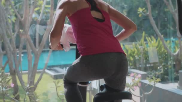 Close-up female legs and ass riding at stationary bike at the gym in slow motion - Filmmaterial, Video
