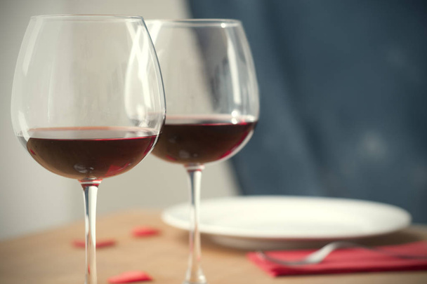 Table à manger avec deux verres à vin une assiette et une fourchette
 - Photo, image