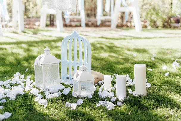 крупным планом фотография красивого свадебного украшения с цветами и свечами на зеленой траве на открытом воздухе
 - Фото, изображение