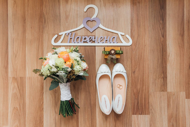 красивый свадебный букет с весенними цветами на деревянном полу с обувью
 - Фото, изображение