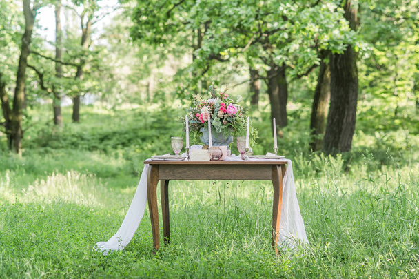 ramo con flores de primavera en la mesa de la boda al aire libre con hierba verde
 - Foto, imagen