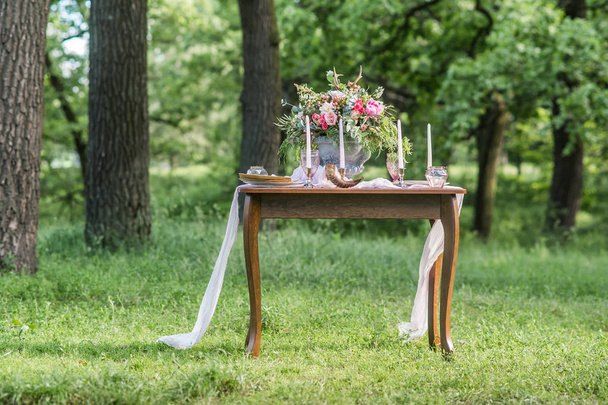 букет с весенними цветами на свадебном столе на открытом воздухе с зеленой травой
 - Фото, изображение