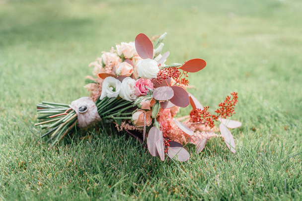 Свадебный букет с весенними цветами на зеленой траве
 - Фото, изображение