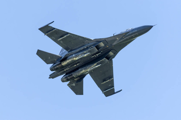 Avion de chasse militaire contre un ciel bleu avec un rétroéclairage d'en bas
. - Photo, image