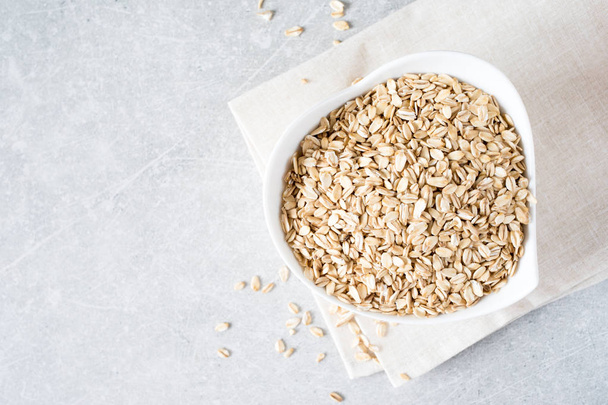 Food. Dry rolled oat flakes oatmeal on bowl. Healthy eating conc - Fotoğraf, Görsel