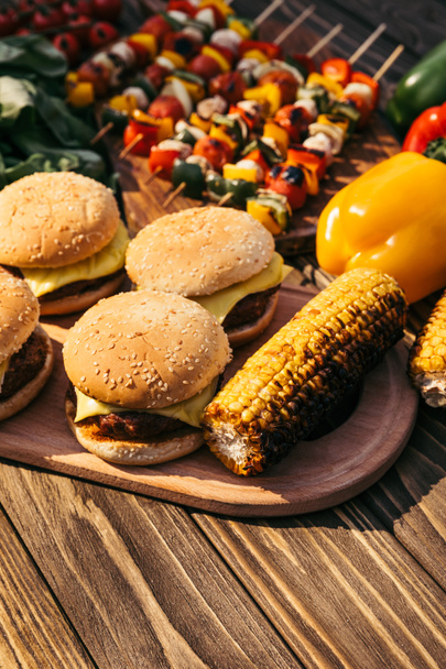 屋外グリルで調理したハンバーガーやトウモロコシ - 写真・画像