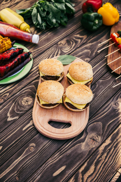 Légumes coupés et burgers grillés pour barbecue en plein air
 - Photo, image