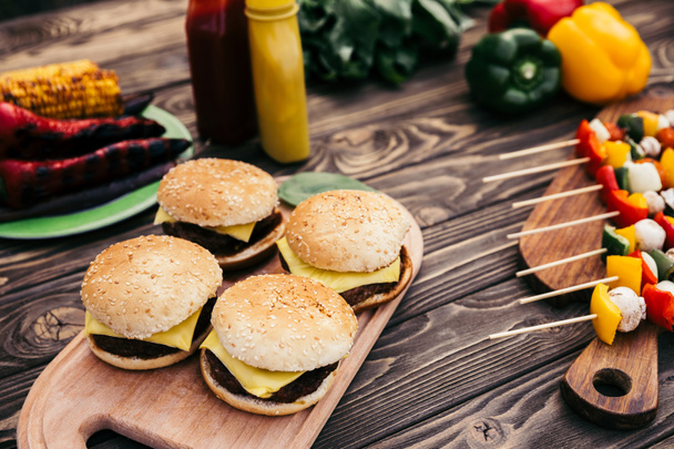 Hete heerlijke hamburgers en groenten gegrilde voor openlucht barbecue - Foto, afbeelding