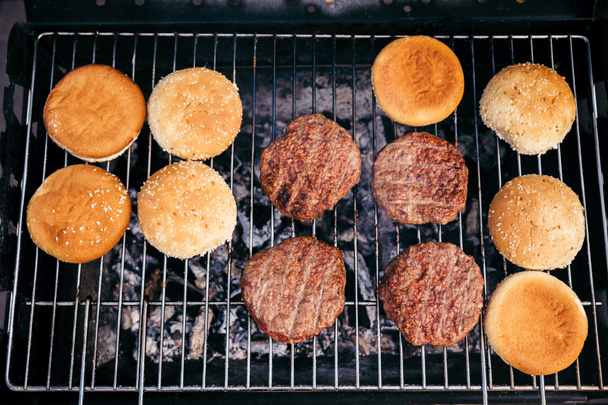 Buns and meat patties grilled for outdoors barbecue - Photo, Image