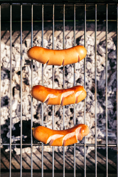Top view of sausages cooked outdoors on grill - Zdjęcie, obraz