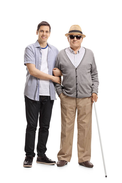 Full length portrait of a young man and a blind mature man isolated on white background - Foto, Bild