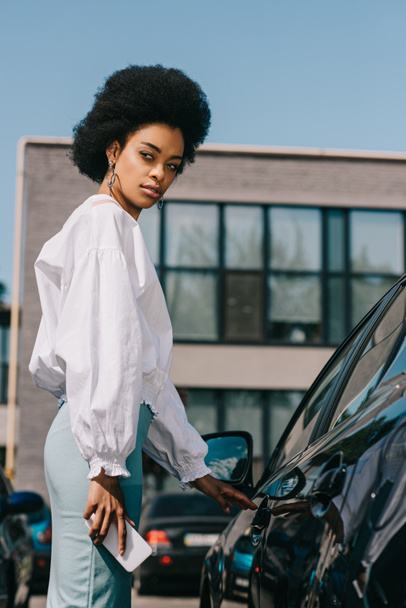 attractive african american businesswoman opening car on parking - 写真・画像
