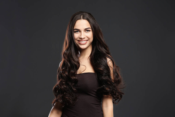 Portrait de beau modèle avec de magnifiques cheveux bouclés sur fond noir
 - Photo, image