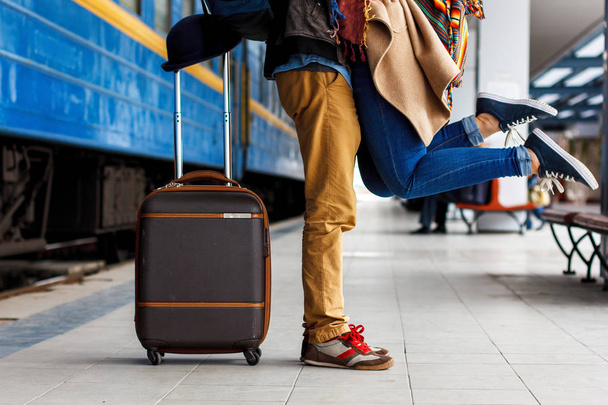 Happy moment of couple love, man in love lifting hi girlfriend in a hug,relaxing front of the urban background,concept about relationship, and travel couple concept. Brown luggage - Photo, Image
