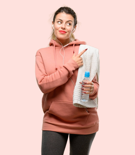 Young sport woman wearing workout sweatshirt pointing away side with finger - Foto, Imagem