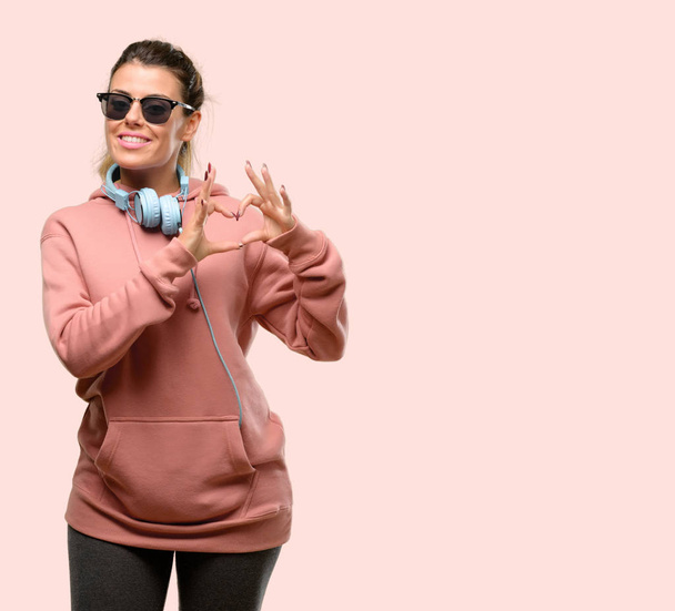 Young sport woman with headphones and sunglasses annoyed with bad attitude making stop sign with hand, saying no, expressing security, defense or restriction, maybe pushing - Φωτογραφία, εικόνα