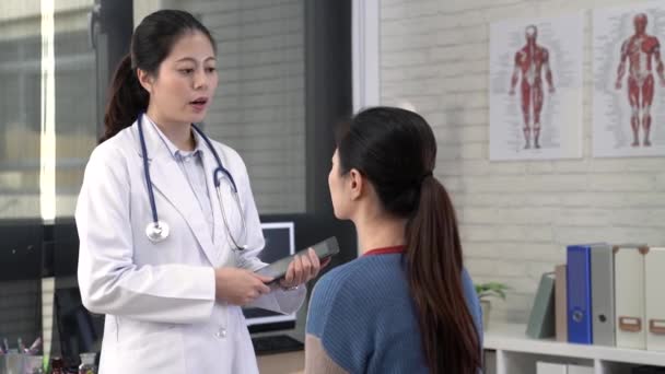 Naispuolinen aasialainen lääkäri, joka tallentaa potilaan tilanteen digitaalisella tabletilla
. - Materiaali, video