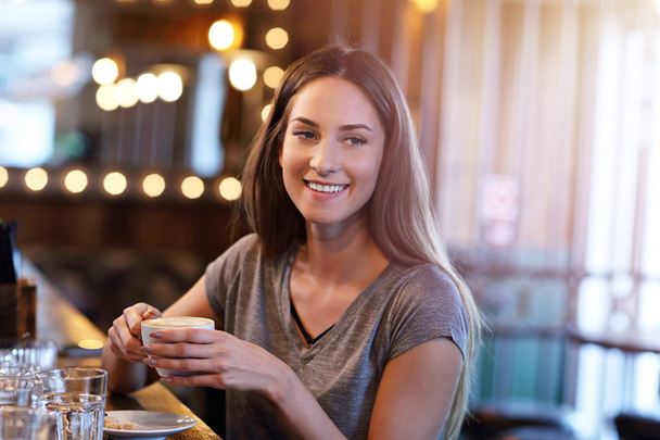 Obrázek mladé ženy pití kávy v kavárně - Fotografie, Obrázek