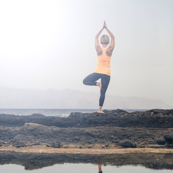Yoga fille méditer et se détendre dans la pose de yoga, vue sur l'océan
 - Photo, image