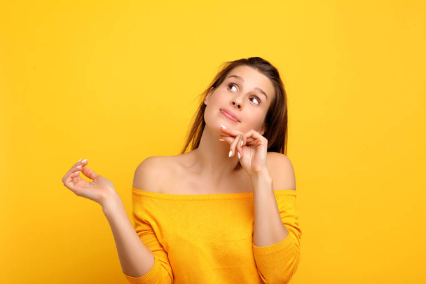 Picture of woman making faces against yellow background - Photo, Image