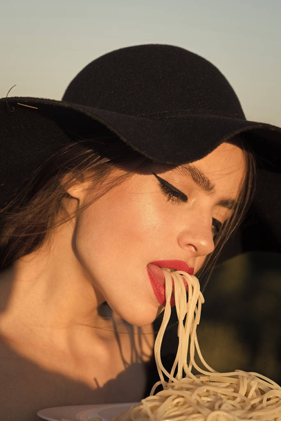 Italian food woman eating spaghetti with wouth in the white plate. - Foto, Imagem