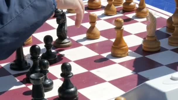 Április 21, 2018 - Kamenskoye, Ukrajna: Gyerekek sakkozni utcában. Utcai szabadtéri sakk versenyeken, sakk óra megnyomja a kéz - Felvétel, videó
