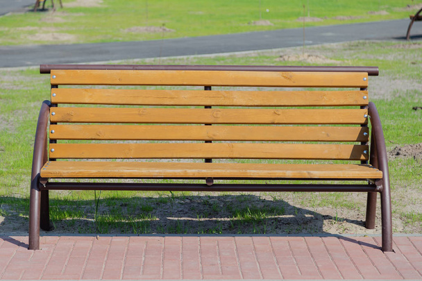 A bench in a park on a green grass on a sunny day - Photo, Image