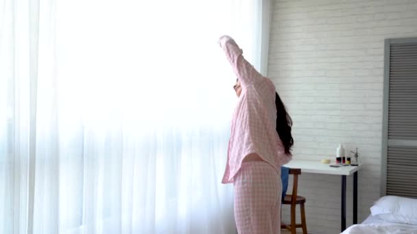 Healthy Asian woman doing exercise in the early morning in her bedroom. She is warming up and getting ready to face task today. - Materiał filmowy, wideo