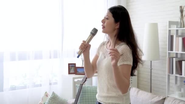 Asian woman indulging in her voice in the living room. She sinks herself into singing. - 映像、動画