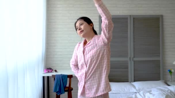 Asian modern young woman finishes her simple exercise and takes a breath. - Video