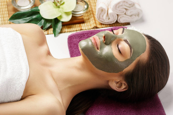 Spa Clay Mask. Woman with clay facial mask and cucumbers on eyes - 写真・画像