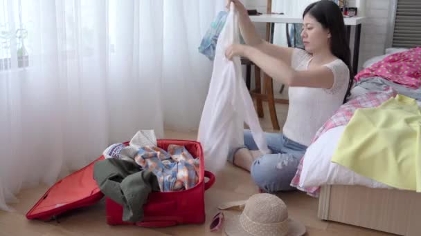 The quick movement of Asian young woman pulling the clothes out of the suitcase. - Imágenes, Vídeo