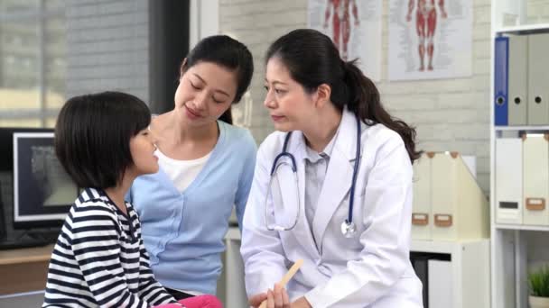hermosa consulta médica con una niña pequeña con su madre en la clínica
 - Metraje, vídeo