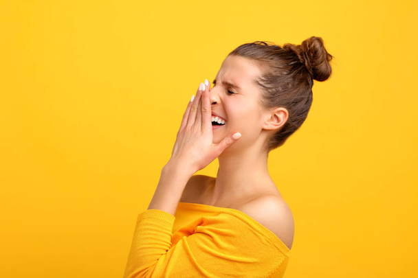 Picture of woman making faces against yellow background - Foto, Bild