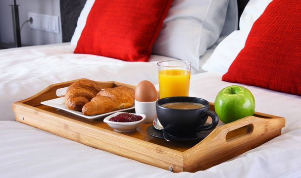 Desayuno en bandeja en la cama en la habitación del hotel - Foto, Imagen
